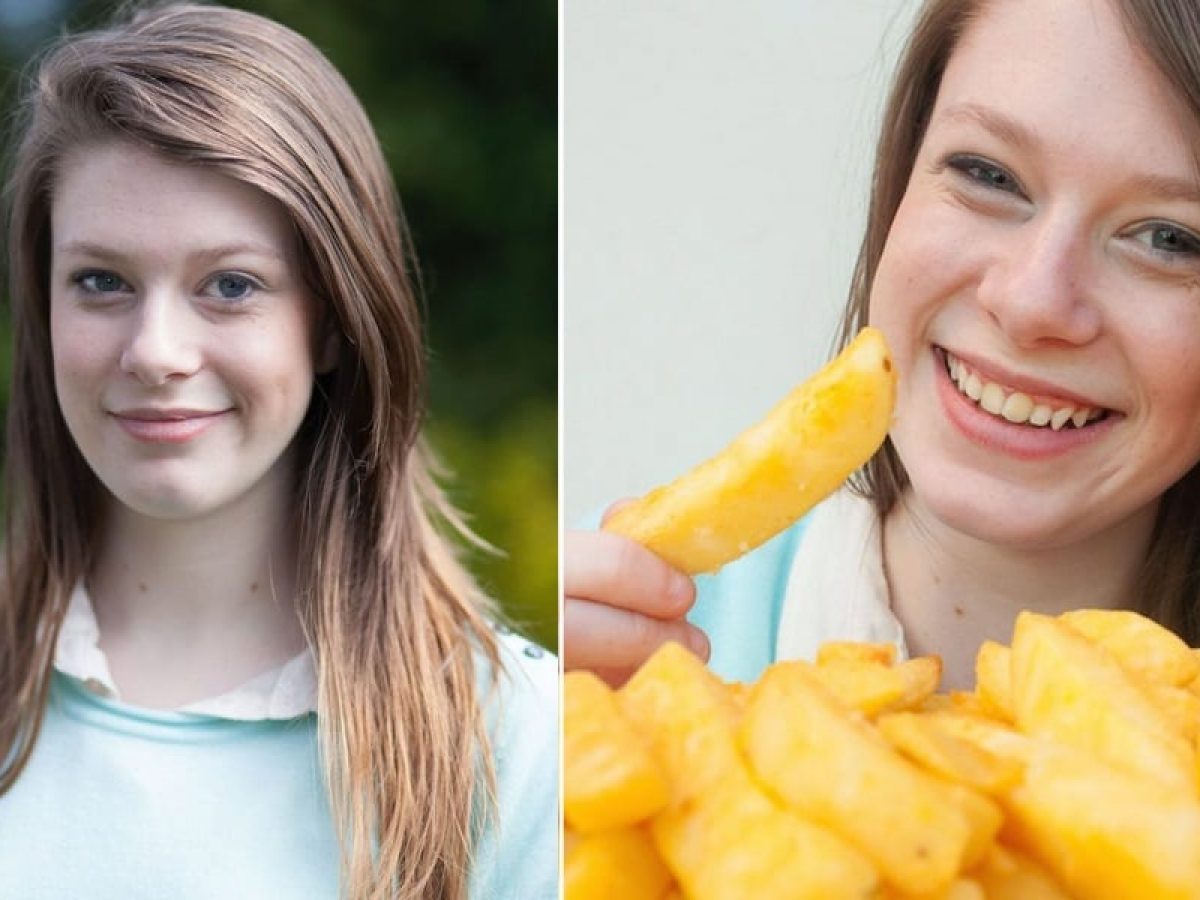 Jovem fêmea comendo batata frita enquanto assiste a um filme na superfície  branca